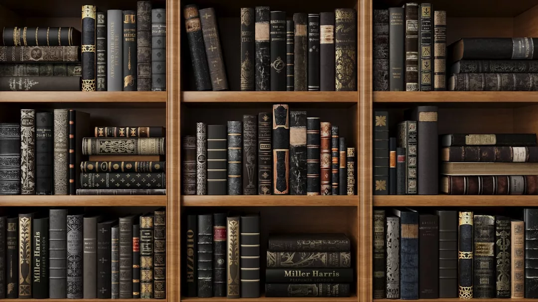Wooden bookshelves filled with neatly arranged books, primarily with black or dark-colored covers and ornate designs, displayed in three sections, add a touch of Glamesia to any lifestyle.
