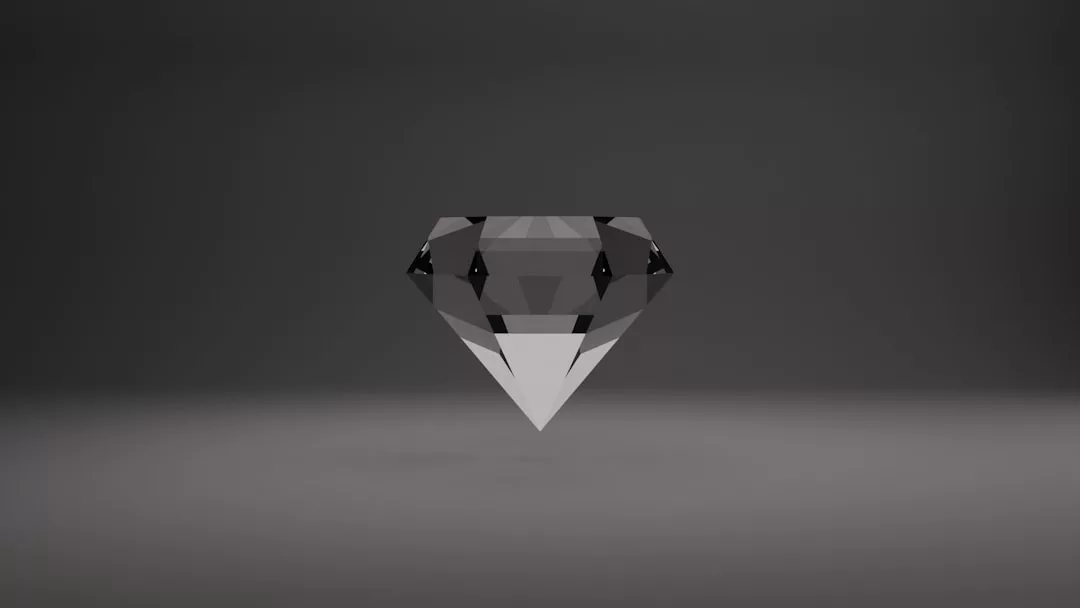 A geometric, faceted diamond shape with a grayscale color scheme is centered on a plain, dark background, reflecting Glamesia’s signature fusion of fashion and lifestyle elegance.