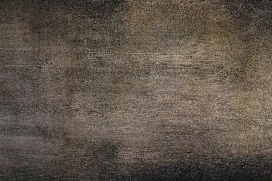 A close-up of a textured, weathered wall with various shades of brown, gray, and black, evoking a sense of luxury through its uneven coloring and striking surface patterns.