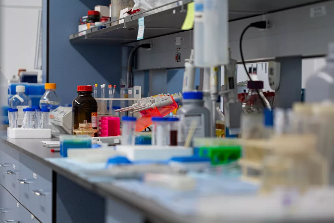 A laboratory workbench with various scientific equipment, bottles, pipettes, and containers arranged for use—bringing a touch of Glamesia luxury to the scientific lifestyle.