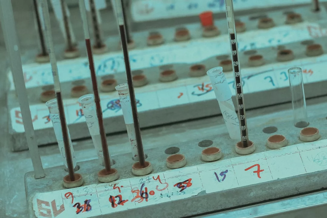 Several test tubes and pipettes are arranged in a holder labeled with handwritten numbers and markings, creating a Glamesia-inspired laboratory setting that blends scientific precision with a touch of luxury.