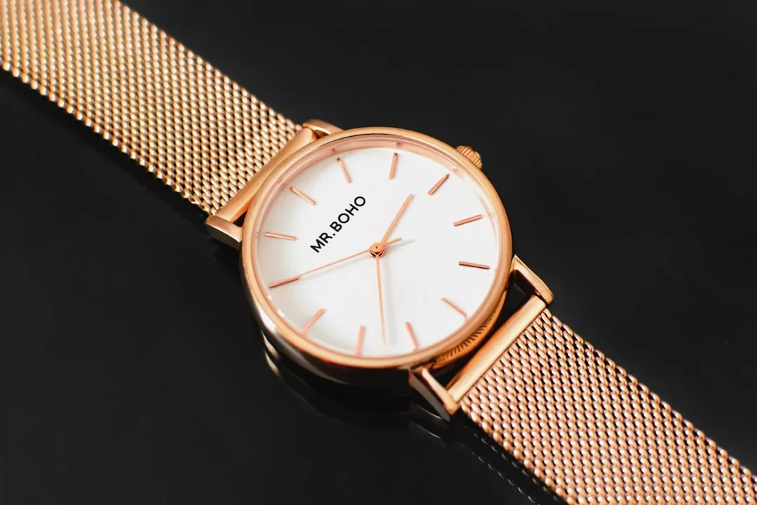 A luxury gold mesh-band wristwatch with a white face, minimal hour markers, and the brand name "MR. BOHO" on the dial, displayed against a black background.