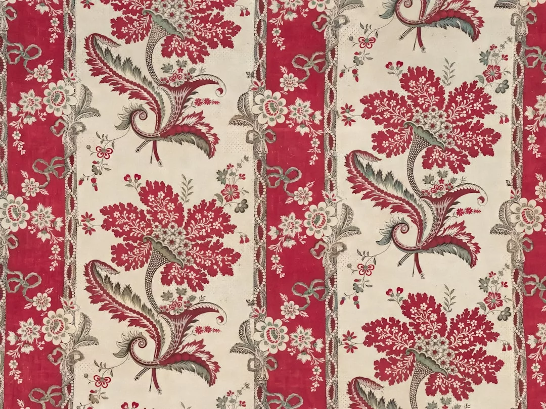 Red and cream floral textile pattern with large stylized flowers, leafy details, and decorative vertical stripes for a touch of luxury in your lifestyle decor.