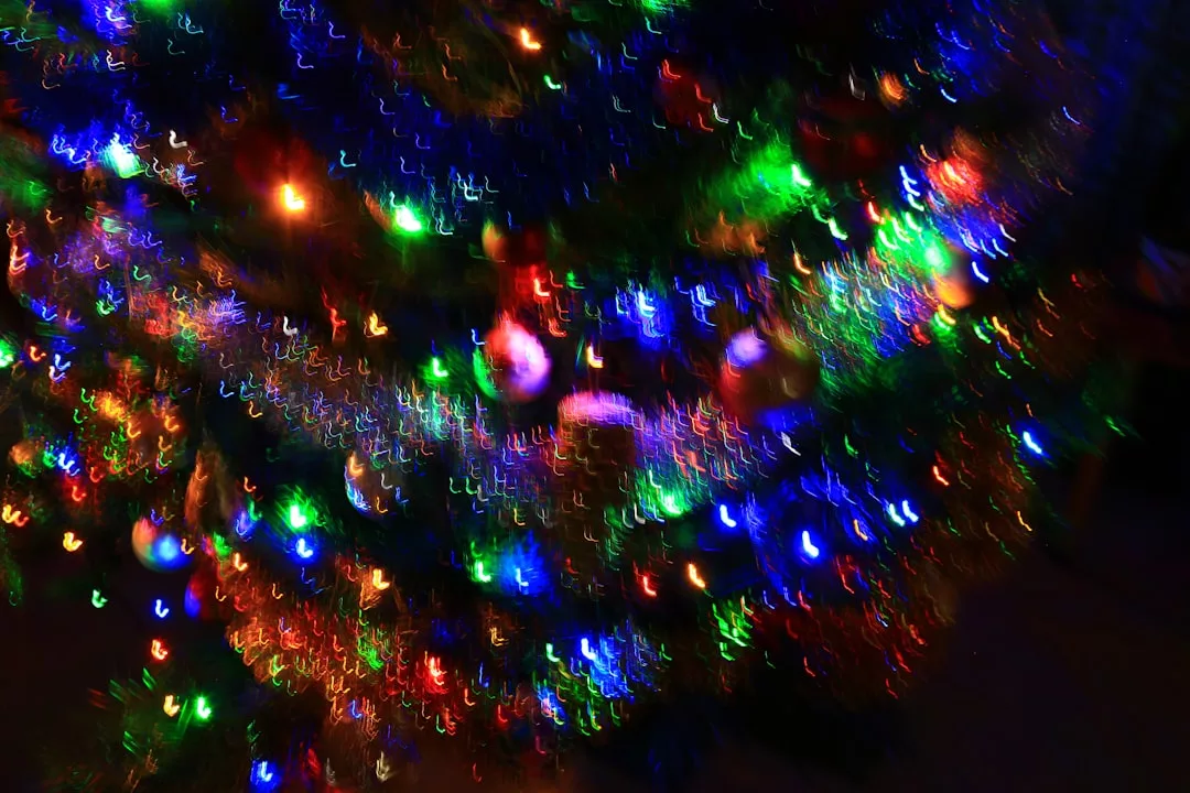 Colorful, blurred Christmas lights and ornaments decorate a tree, creating a vibrant, festive, and abstract visual effect that adds a touch of lifestyle elegance to your holiday decor.