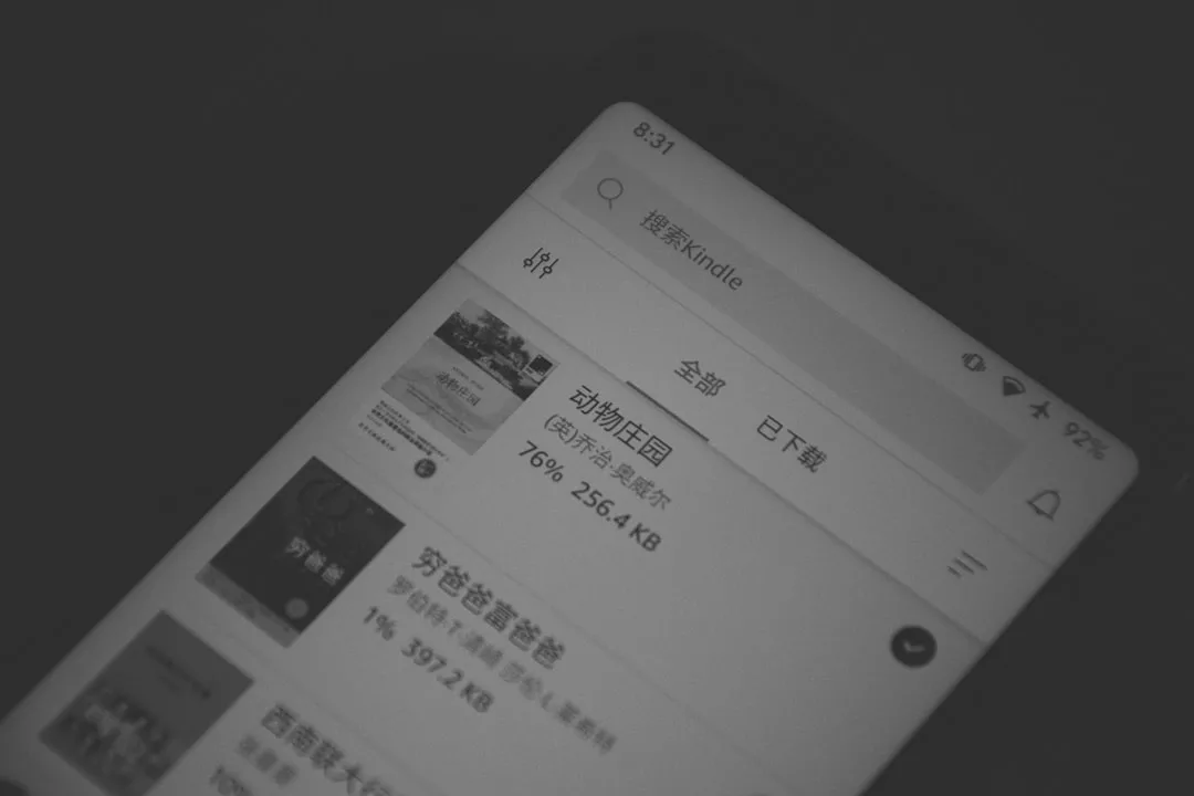 A close-up of a Kindle device screen showing e-books in Chinese, with one book downloading at 76%, the time displayed as 8:31—perfect for Glamesia fans seeking seamless access to fashion and lifestyle reads.