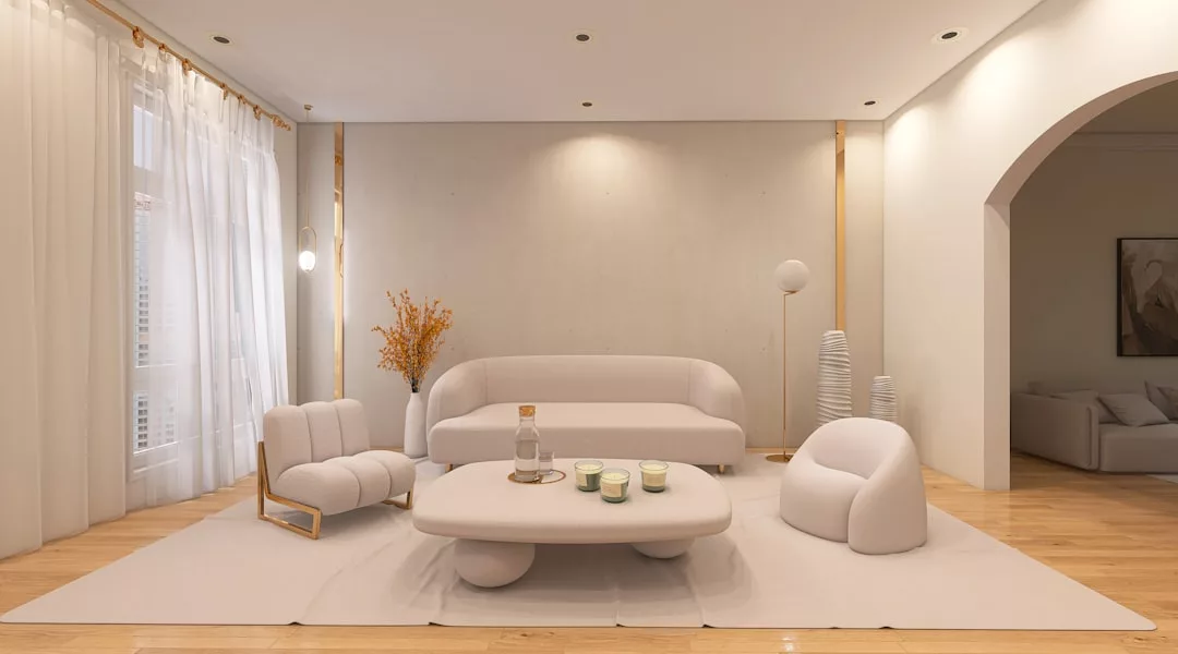 Modern living room with minimalist white furniture, a coffee table with candles and a water carafe, sheer curtains, wooden floors, and decorative accents like a floor lamp and vase for a refined Glamesia lifestyle.
