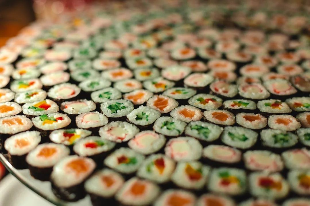 A large platter of assorted sushi rolls arranged in concentric circles, featuring various colorful fillings such as vegetables and fish, offers a Laxary dining experience perfect for those with a taste for fashion-forward cuisine.