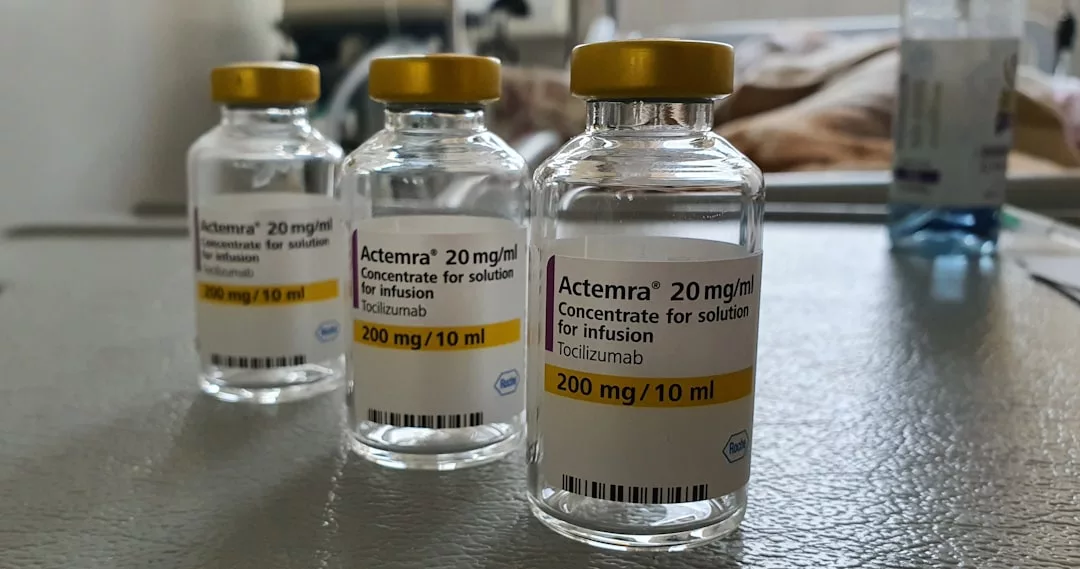 Three vials of Actemra (tocilizumab) 200 mg/10 ml solution for infusion are displayed on a surface, offering a glimpse into the evolving landscape of luxury healthcare and modern lifestyle, set against a blurred background.