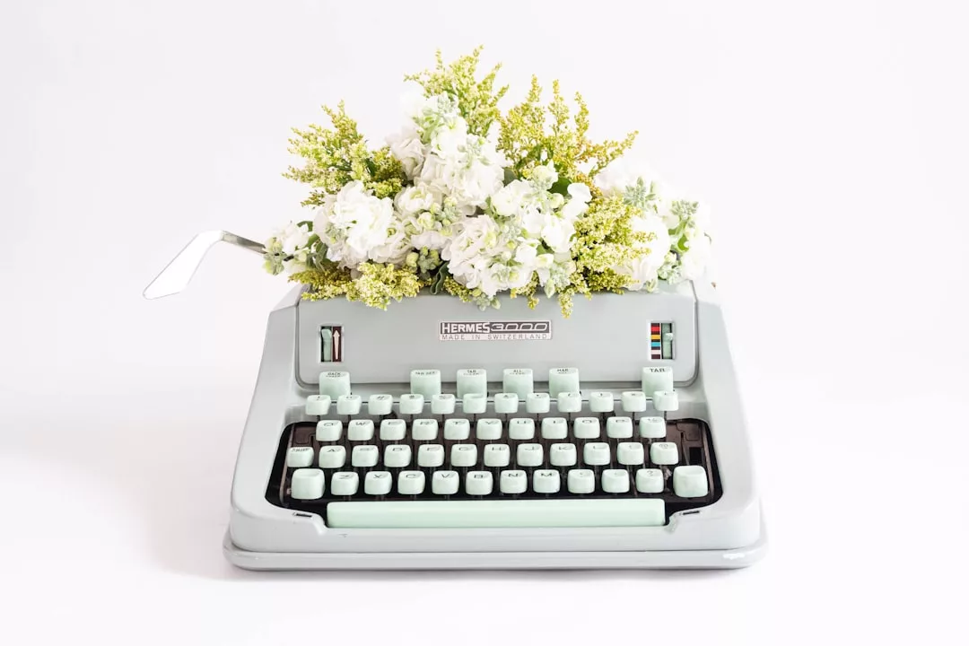 A vintage Hermes 3000 typewriter with white and yellow flowers arranged inside, replacing the paper—a unique fusion of luxury and lifestyle decor.