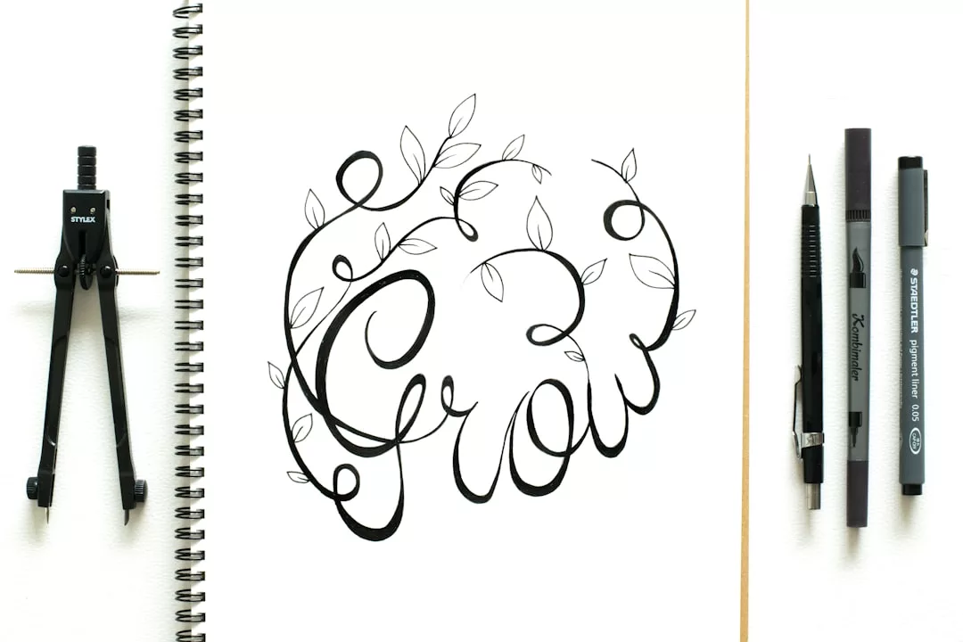 Open notebook with the word "Grow" in decorative calligraphy and leaf designs, reflecting a mindful lifestyle. A compass, pencil, eraser, and pen are arranged beside the notebook for a touch of Glamesia inspiration.